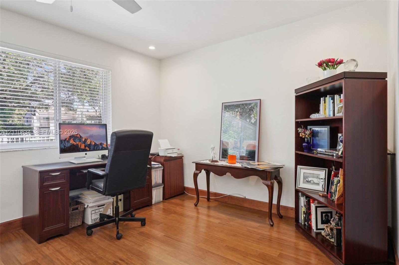 Wood-finish flooring, large window with horizontal blinds, and recessed ceiling lighting