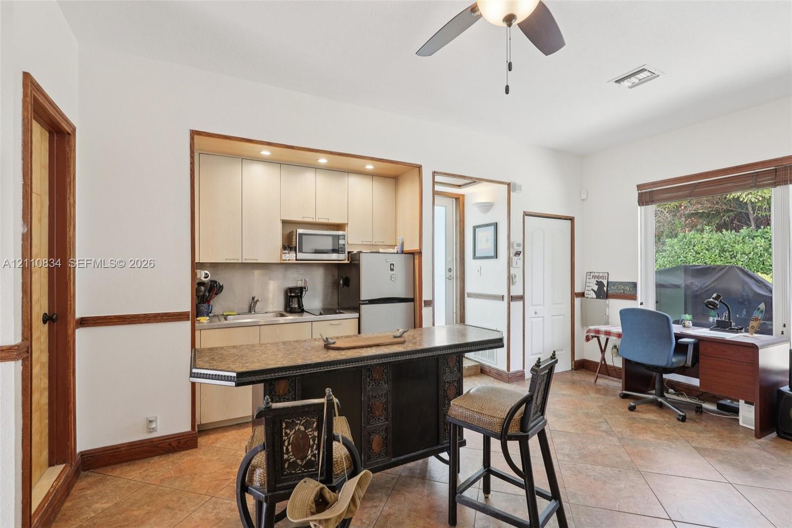 Kitchen featuring custom light-finish cabinetry, recessed lighting, tile flooring, and a built-in island with decorative detailing