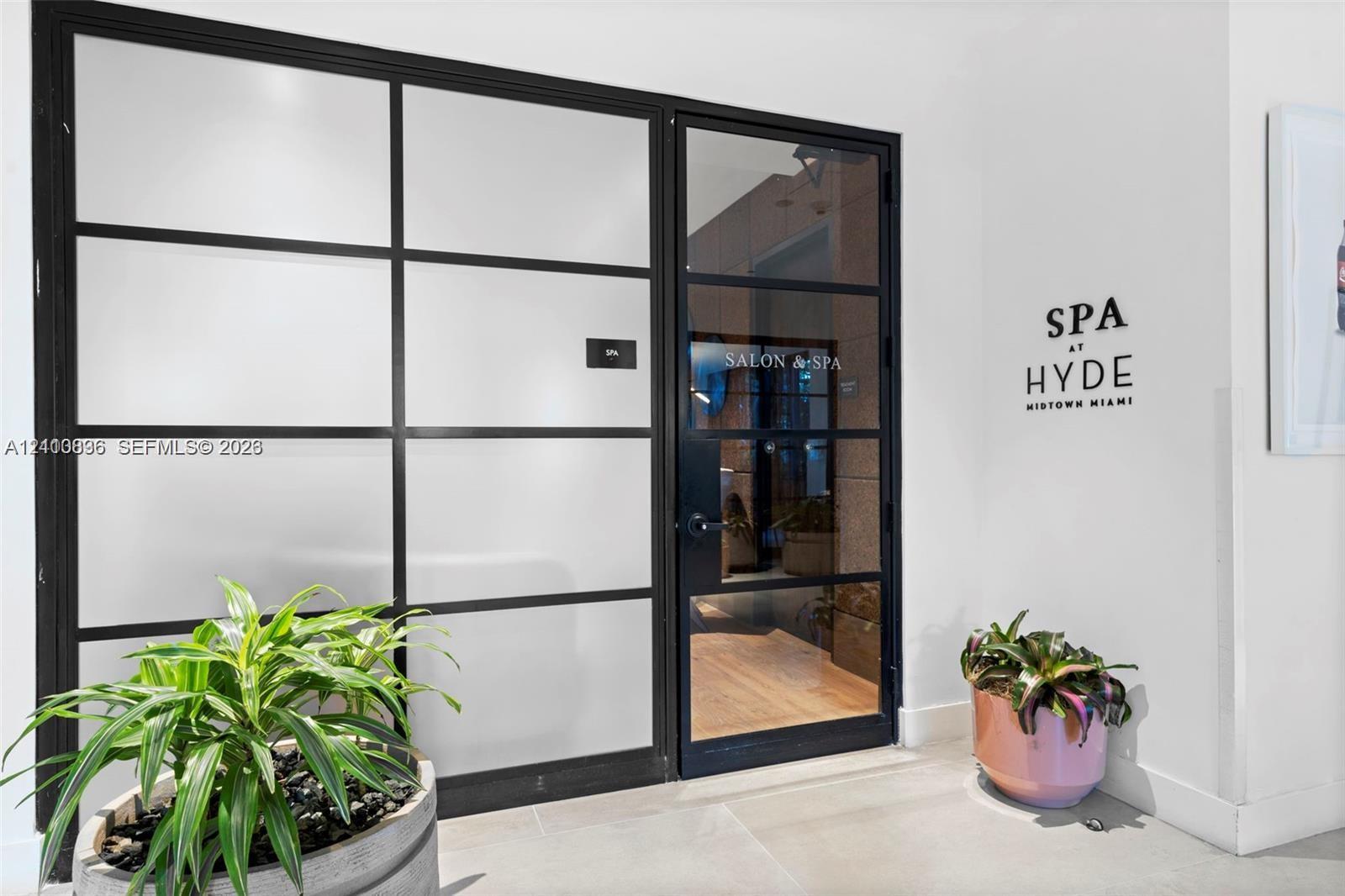Black metal-framed glass partition with frosted panels and matching entry door featuring clear glass insets