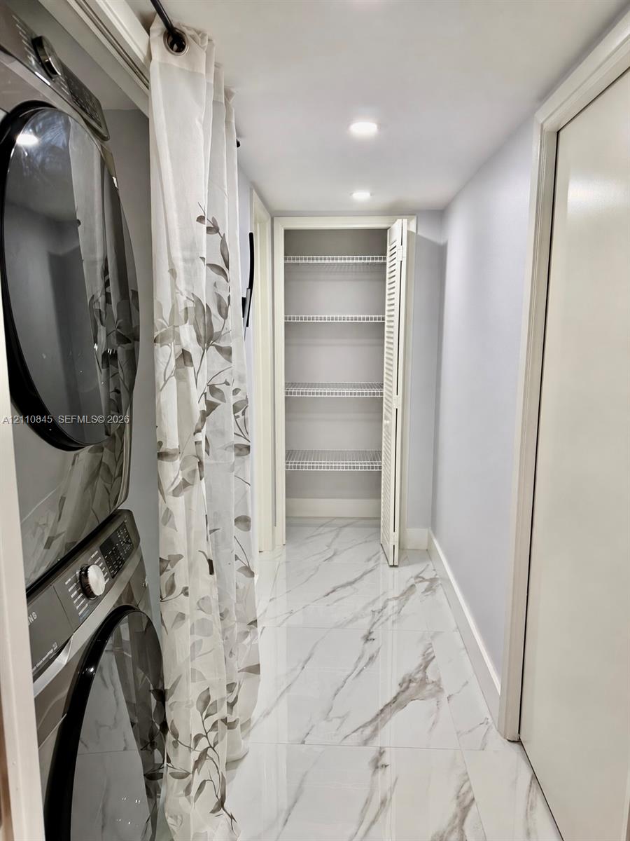 Utility space featuring large-format stone-look porcelain tile flooring, recessed ceiling lighting, and a built-in closet with ventilated wire shelving