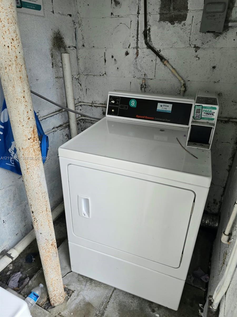 Commercial-grade dryer featuring a white finish and integrated payment console