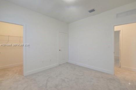 Neutral-toned carpeting, high ceilings, solid-core interior doors, and walk-in closet with built-in wire shelving