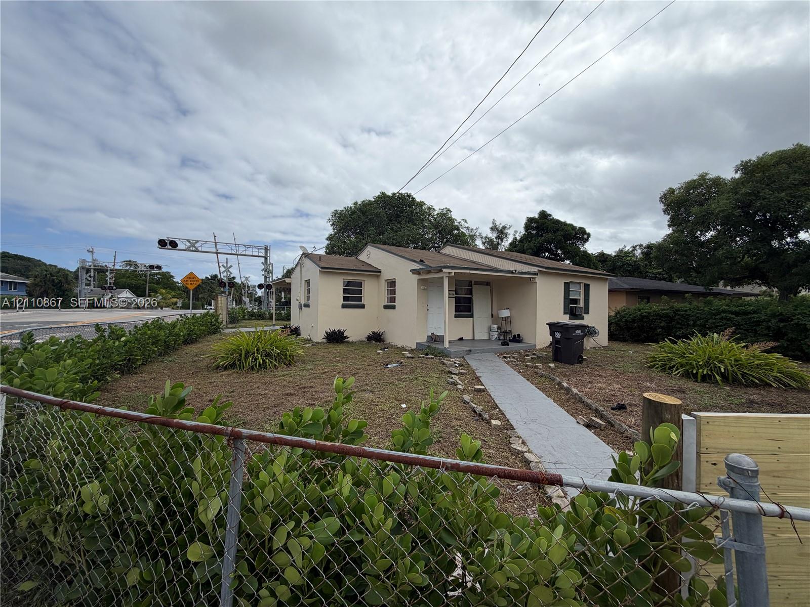 Single-story residence with a stucco exterior, covered front porch, and concrete walkway