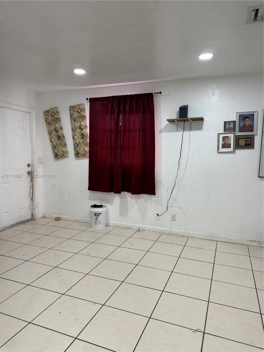Interior space featuring square tile flooring and recessed ceiling lighting
