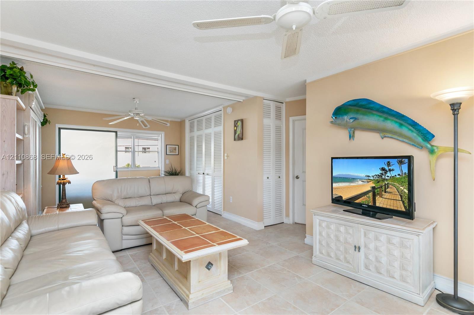 Neutral tile flooring, ceiling fans, and louvered-panel closet doors