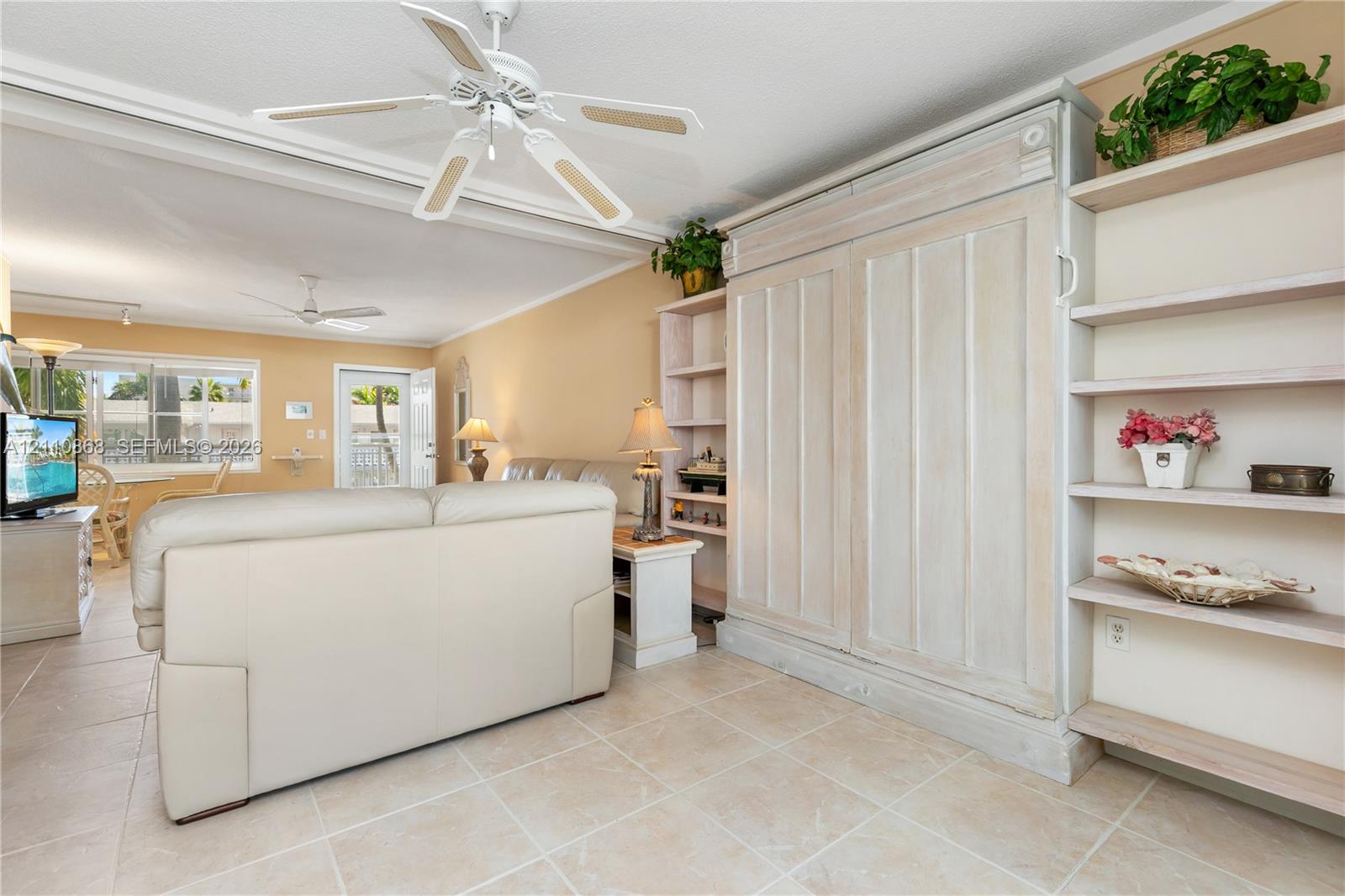 Built-in cabinetry with integrated shelving, tile flooring, and ceiling-mounted fans