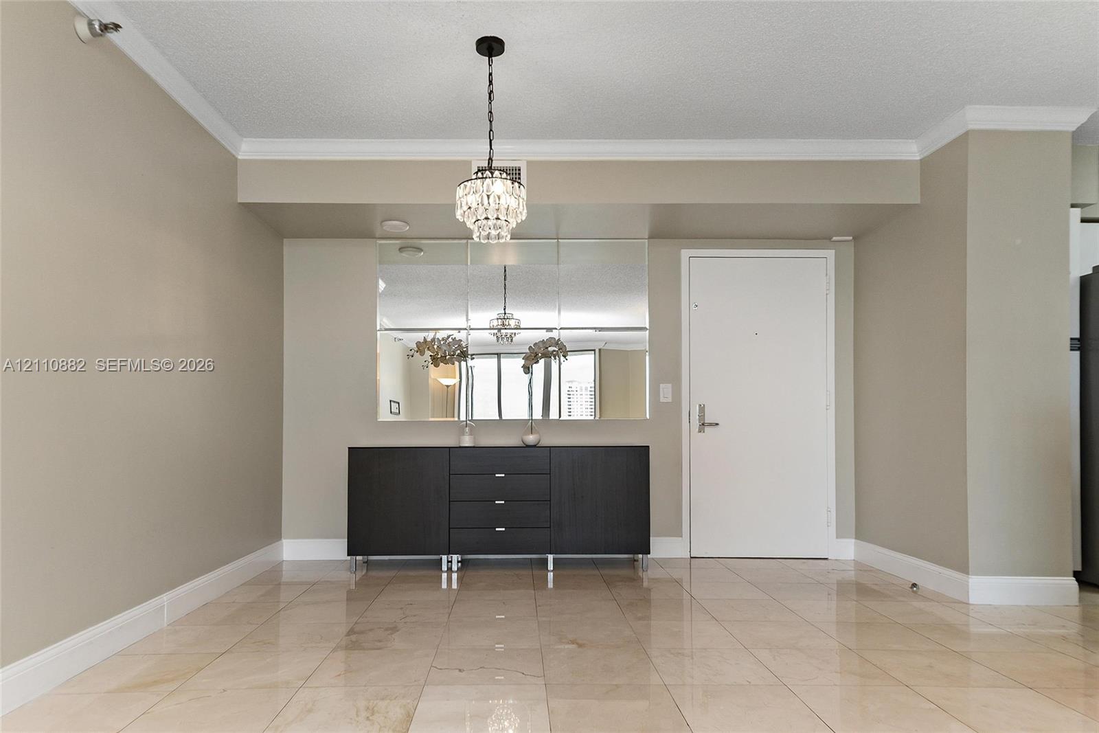 Polished stone tile flooring, multi-pane wall mirror, and crystal-style chandelier lighting Polished stone tile flooring, multi-pane wall mirror, and crystal-style chandelier lighting