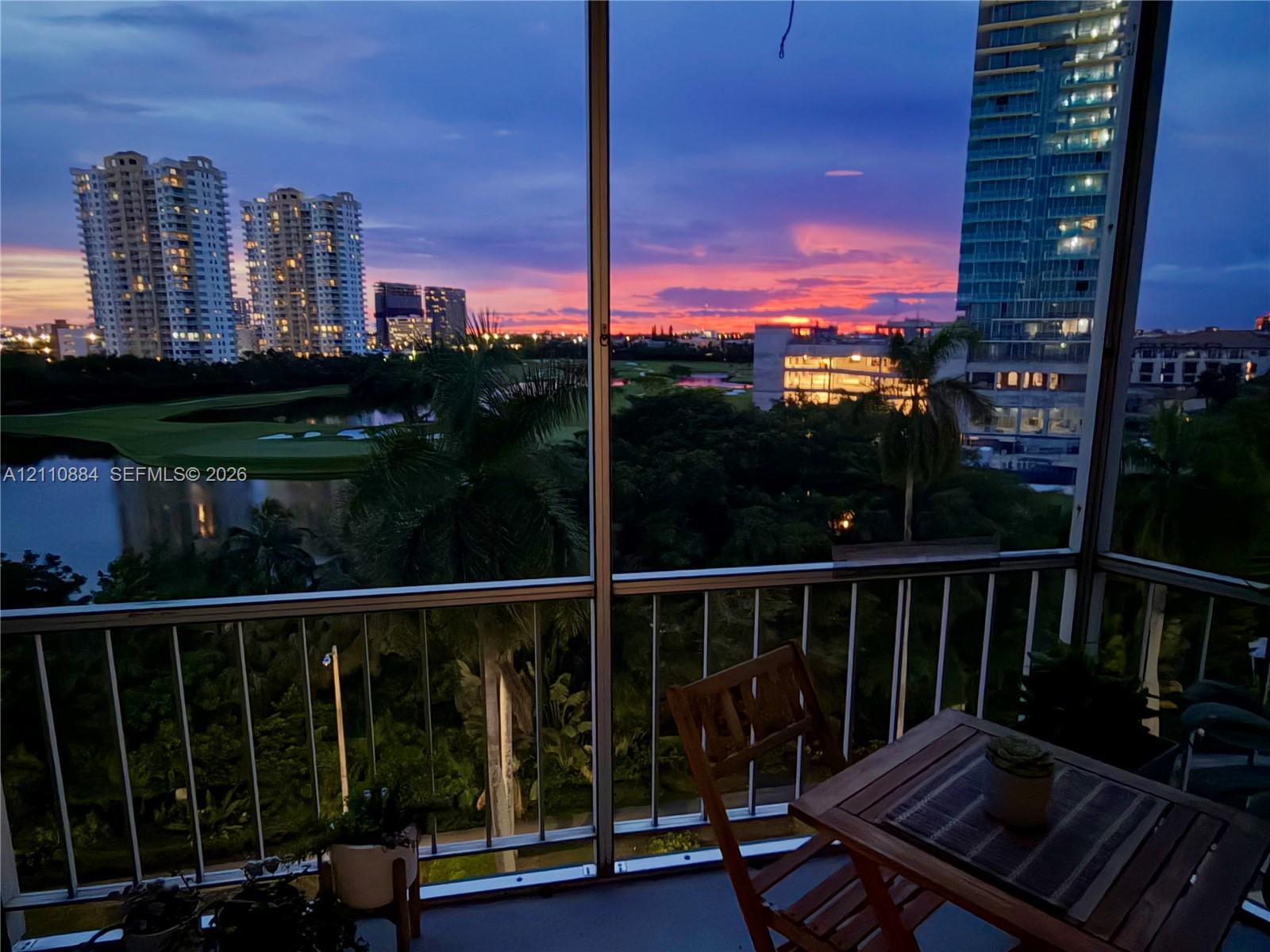 Screened balcony featuring a metal railing and a direct perspective of the landscape, water, and horizon