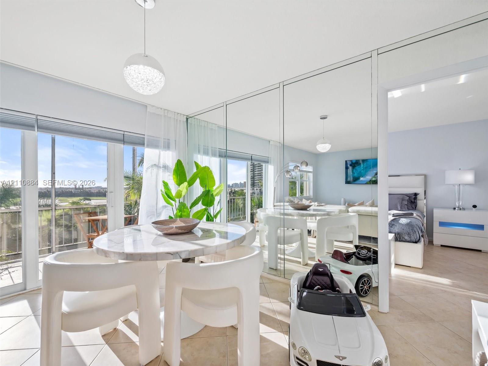 Floor-to-ceiling mirror wall, tile flooring, brand new impact rated glass sliding balcony doors, and custom spherical pendant lighting