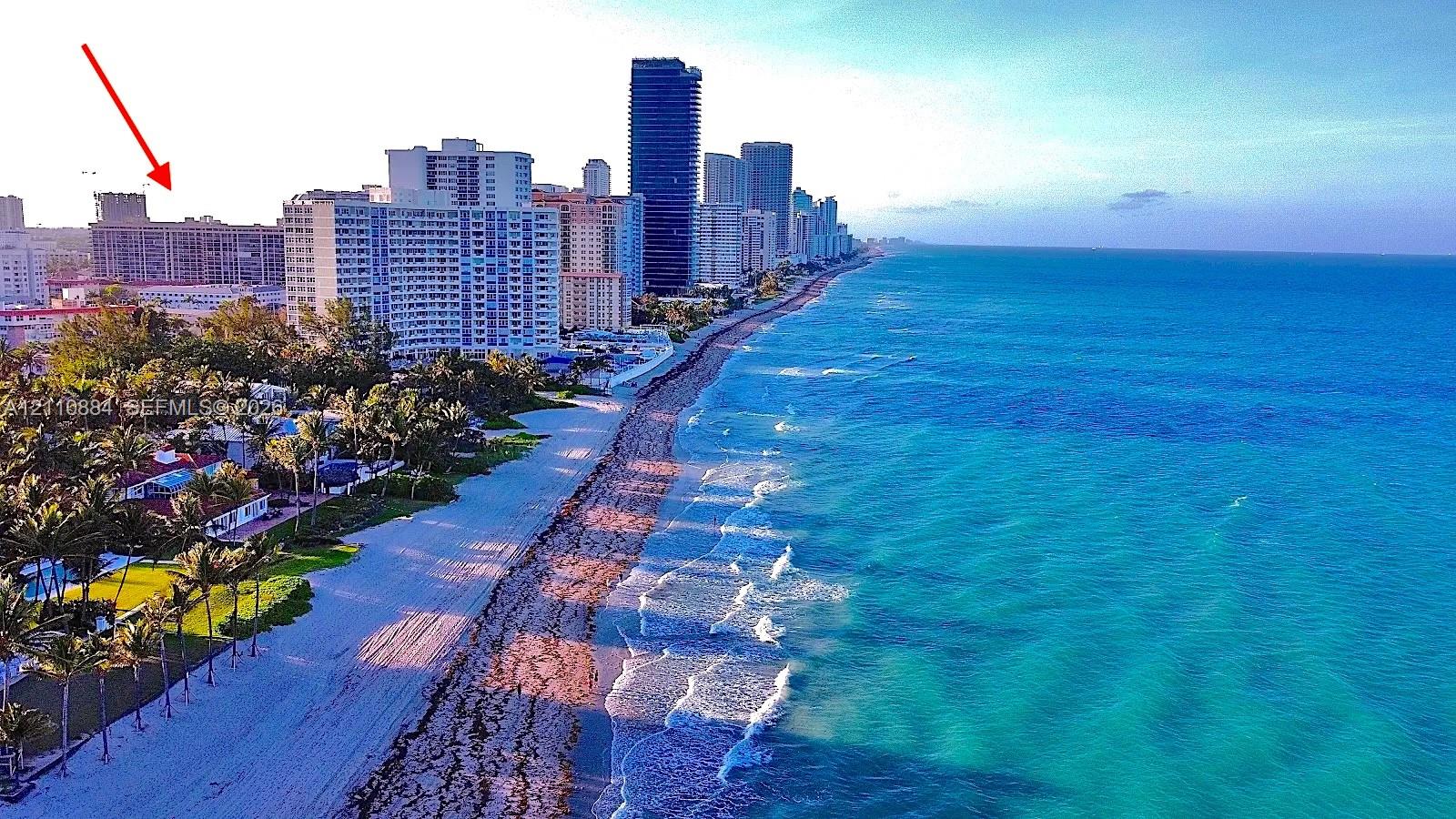 Aerial perspective featuring coastal shoreline and high-rise development