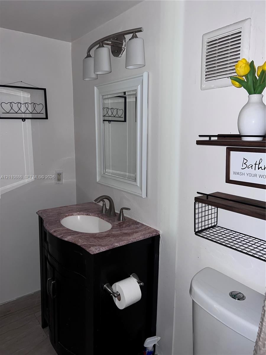 Neutral-toned walls, tile flooring, multi-pane window with wood-trim finish, and a circular flush-mount ceiling light