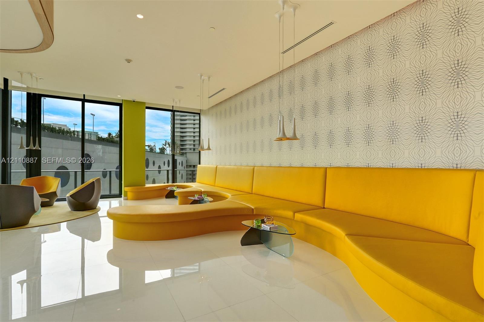 Floor-to-ceiling glass windows, built-in curvilinear banquette seating, polished tile flooring, recessed ceiling lighting, and pendant fixtures