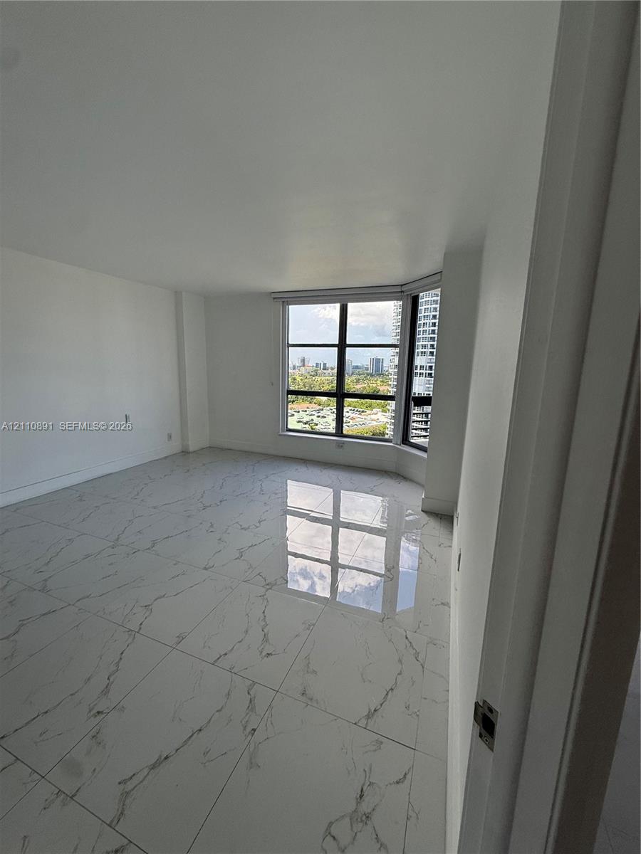 Large-format polished tile flooring, floor-to-ceiling windows with grid detailing, and panoramic urban scenery