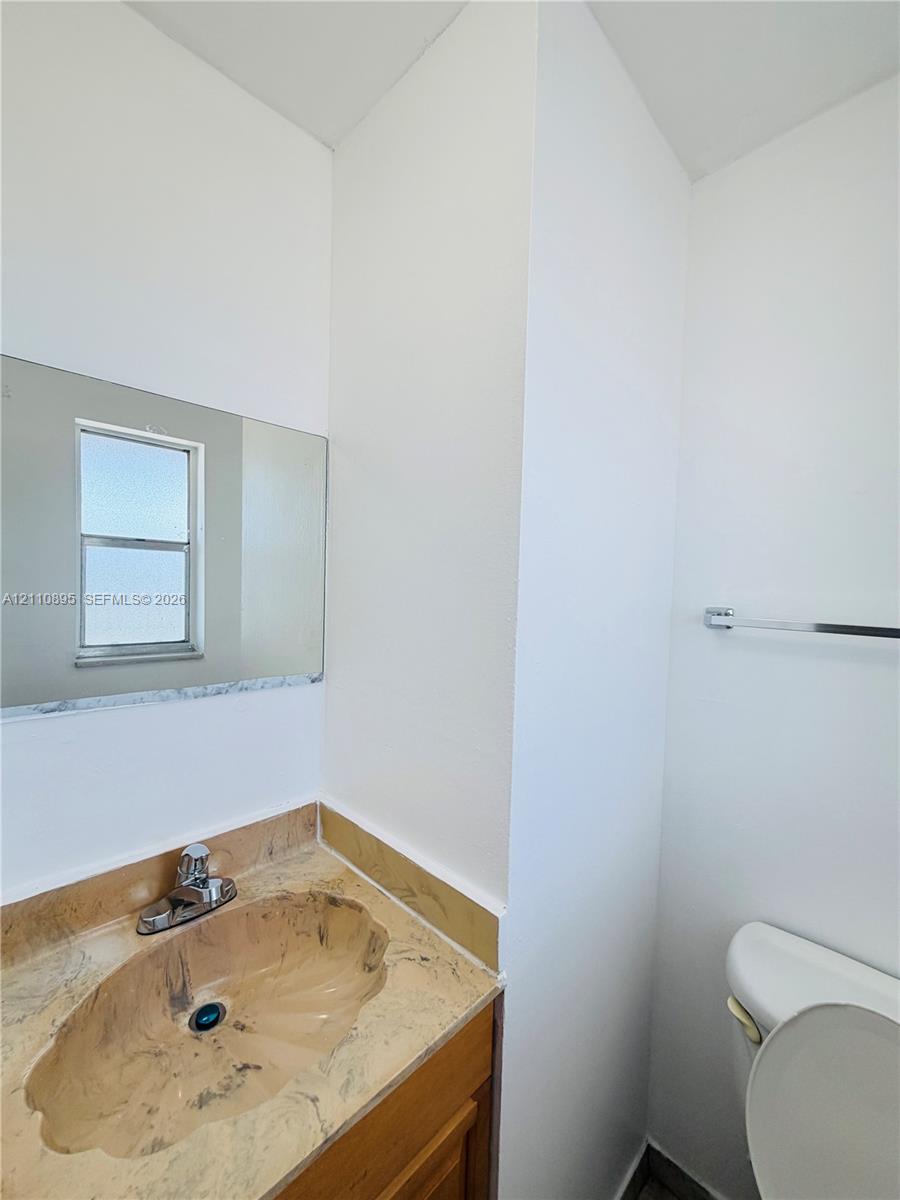 Integrated vanity featuring a stone-patterned countertop, an oval-molded sink, a polished metal faucet, and a wall-mounted rectangular mirror