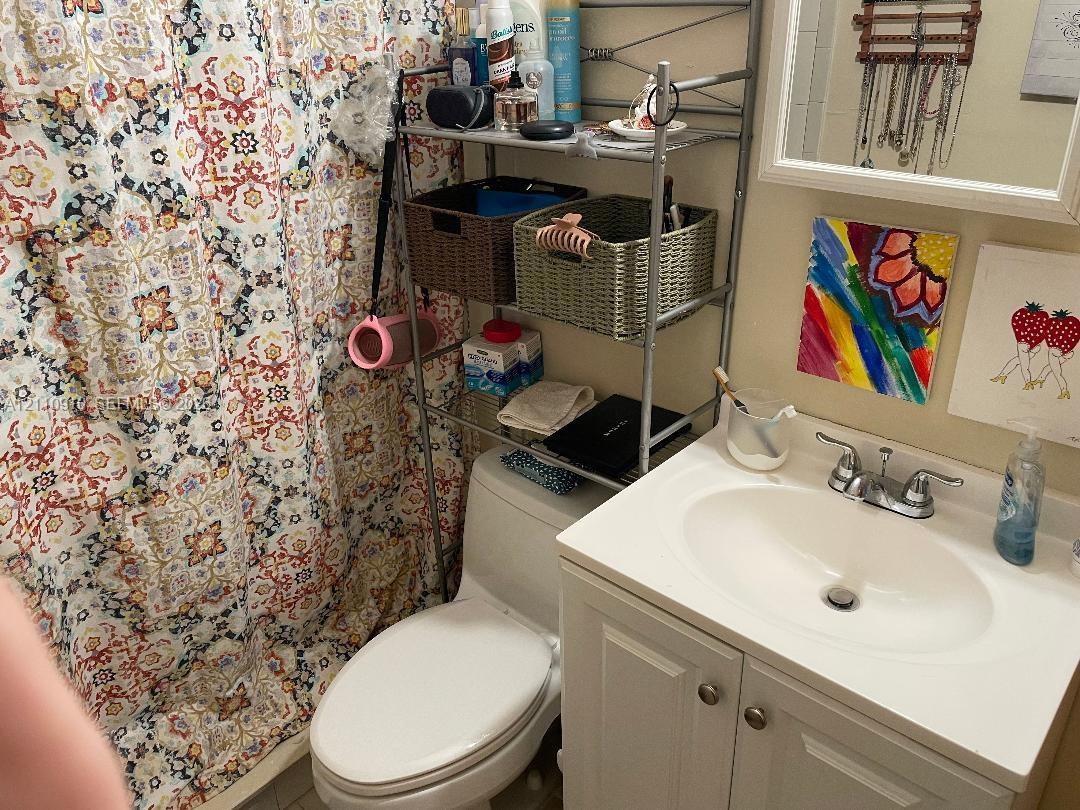 White vanity cabinet with integrated basin, polished chrome double-handle faucet, and framed wall mirror