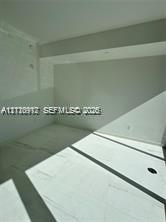 Large-format neutral tile flooring paired with clean white walls and recessed ceiling lighting