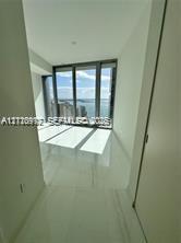 Floor-to-ceiling glass windows, polished tile flooring, and neutral wall finishes