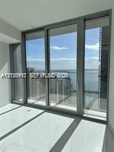 Floor-to-ceiling glass sliding doors with metallic frames and polished tile flooring