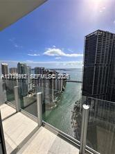 Covered balcony featuring tile flooring and a transparent glass panel railing