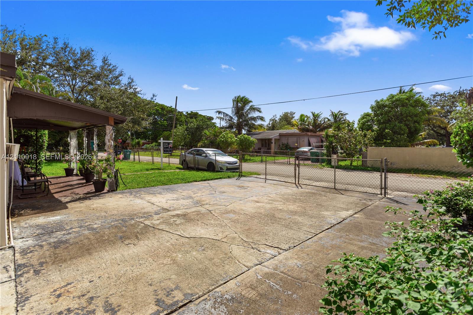 Concrete driveway, chain-link perimeter fencing, and covered outdoor patio area Concrete driveway, chain-link perimeter fencing, and covered outdoor patio area