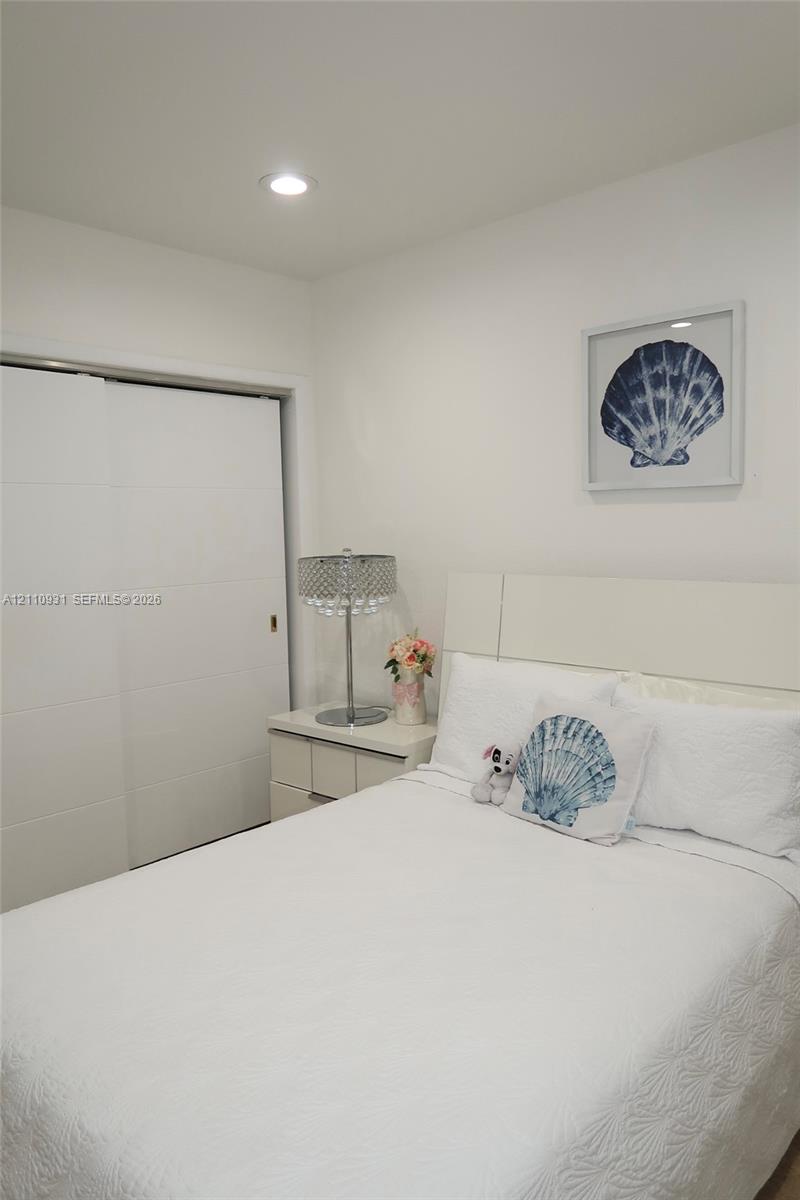 Room featuring a neutral color palette, recessed lighting, and a sliding panel closet door