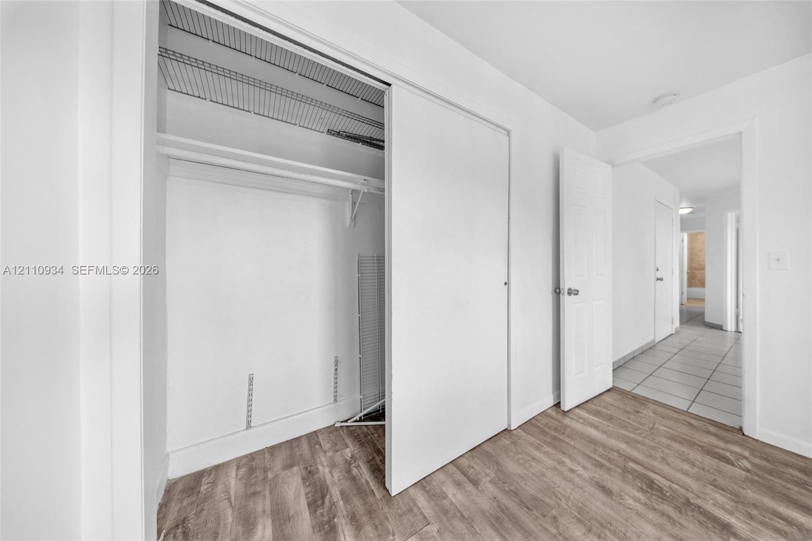 Closet featuring sliding doors and wire shelving with wood-finish flooring throughout the room