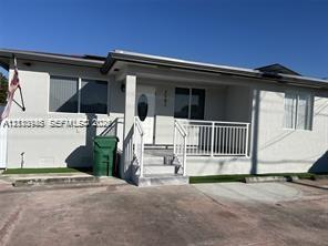 Single-story exterior featuring a covered front porch, white railings, concrete steps, and a concrete driveway