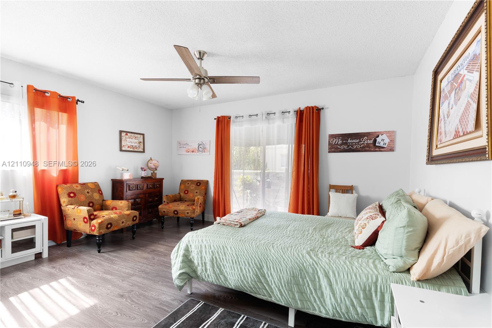 Wood-finish flooring, sliding glass door with exterior access, and ceiling fan with integrated lighting