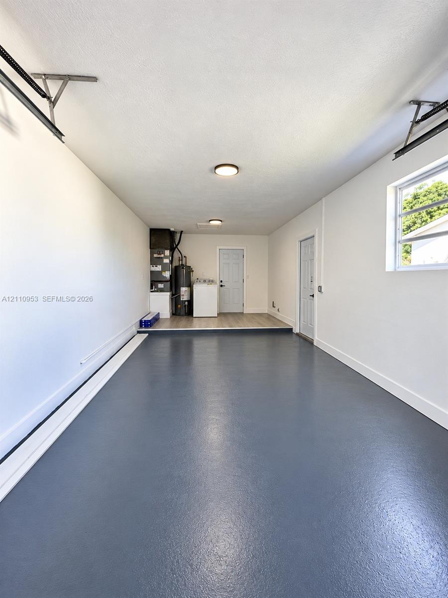 Attached two-car garage featuring sealed epoxy flooring, recessed ceiling lighting, and a window with horizontal panes