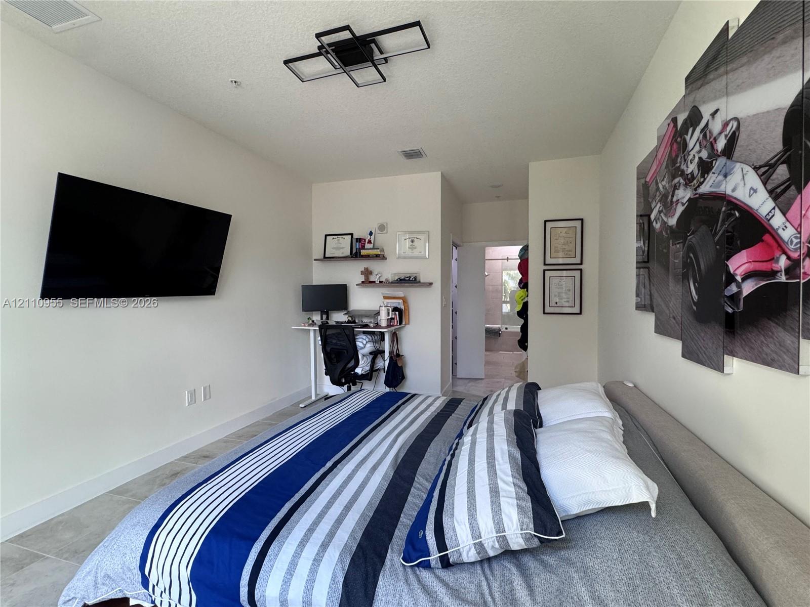 Room featuring neutral wall finishes, tile flooring, and a modern geometric flush-mount light fixture