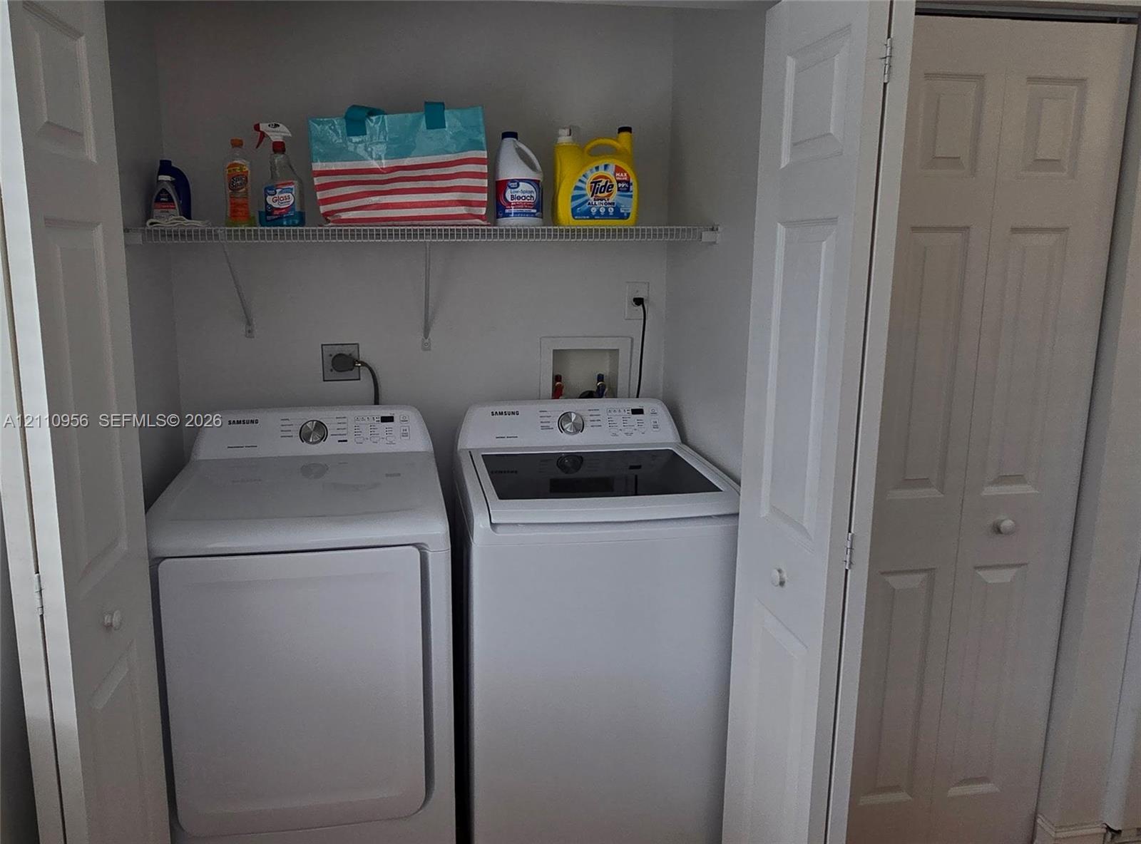 Laundry closet featuring white bifold doors and a metal wire shelving unit