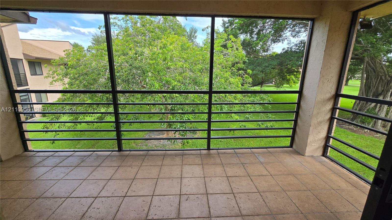 Screened-in balcony with tile flooring and black metal framing