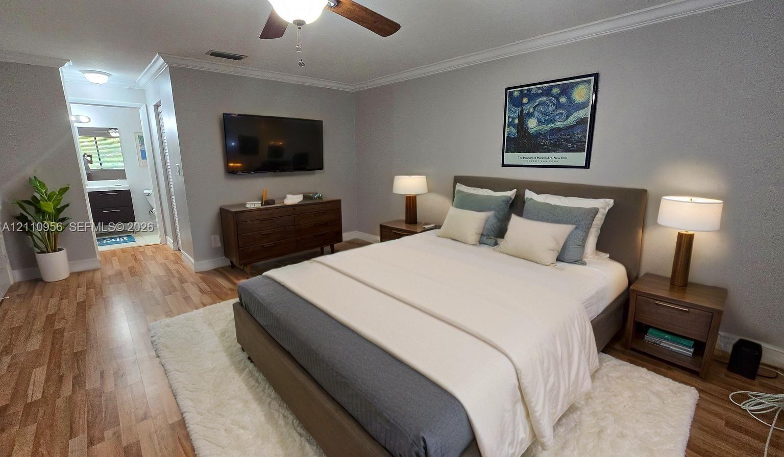 Virtual Bedroom featuring wood-finish flooring, crown molding, and a ceiling fan with integrated lighting