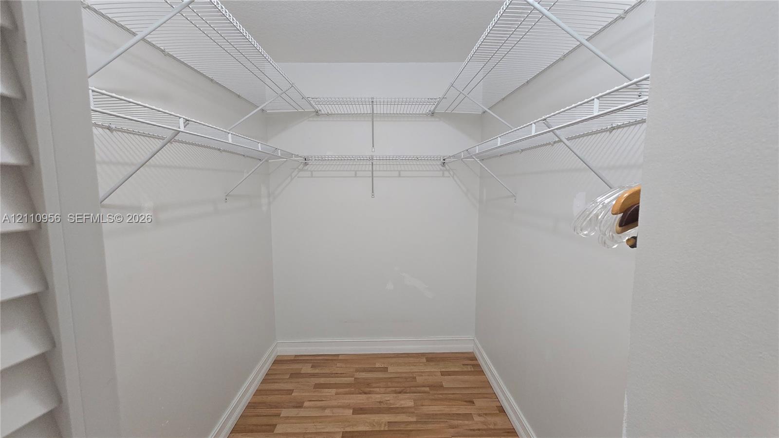 Storage area featuring wood-finish flooring and multi-level white wire shelving