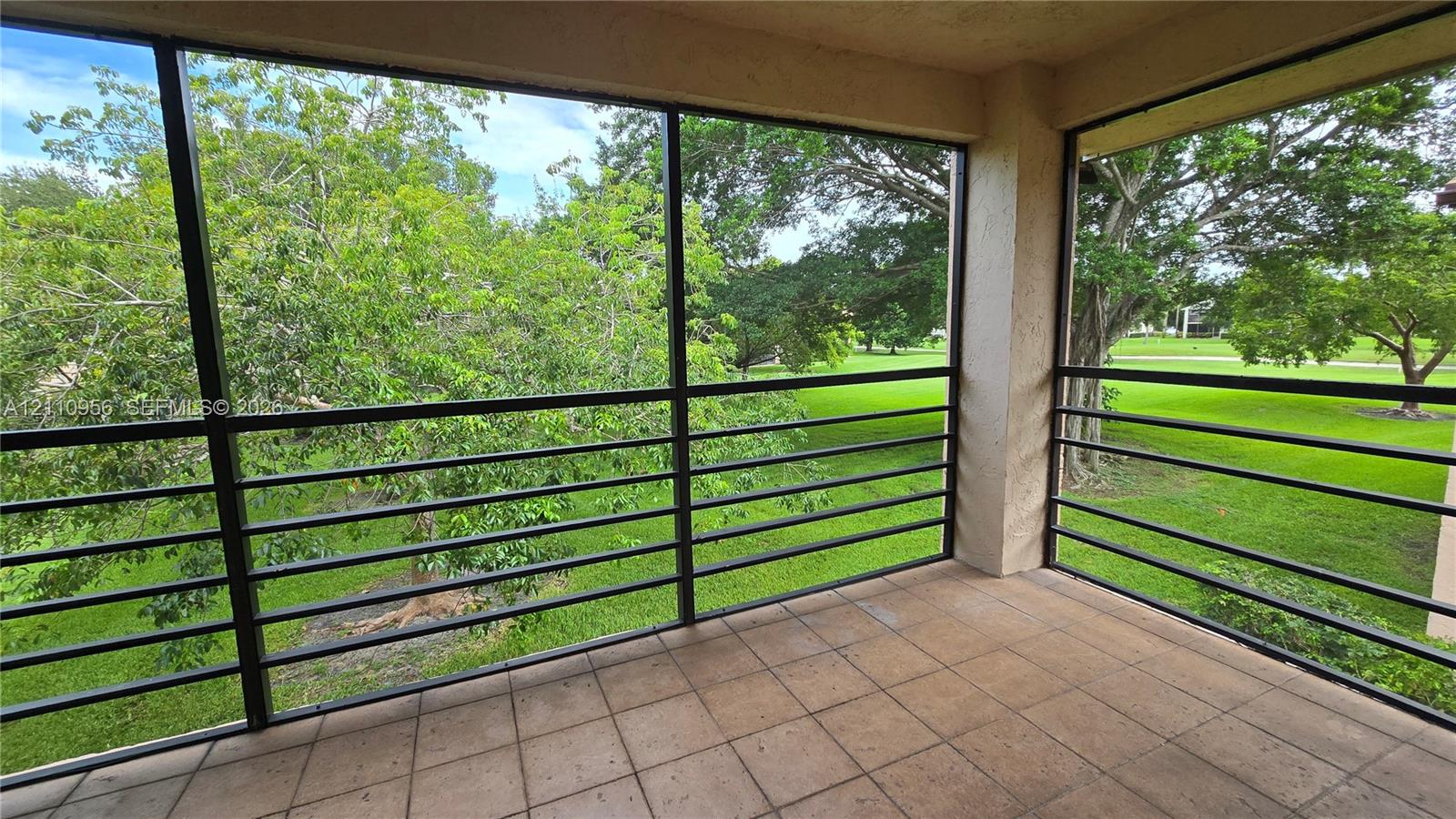 Screened-in balcony featuring tile flooring and metal railing