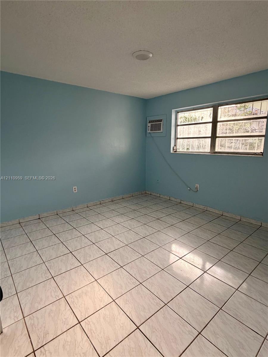 Interior space featuring ceramic tile flooring, neutral wall tones, multi-pane windows, and a recessed ceiling lighting fixture Interior space featuring ceramic tile flooring, neutral wall tones, multi-pane windows, and a recessed ceiling lighting fixture
