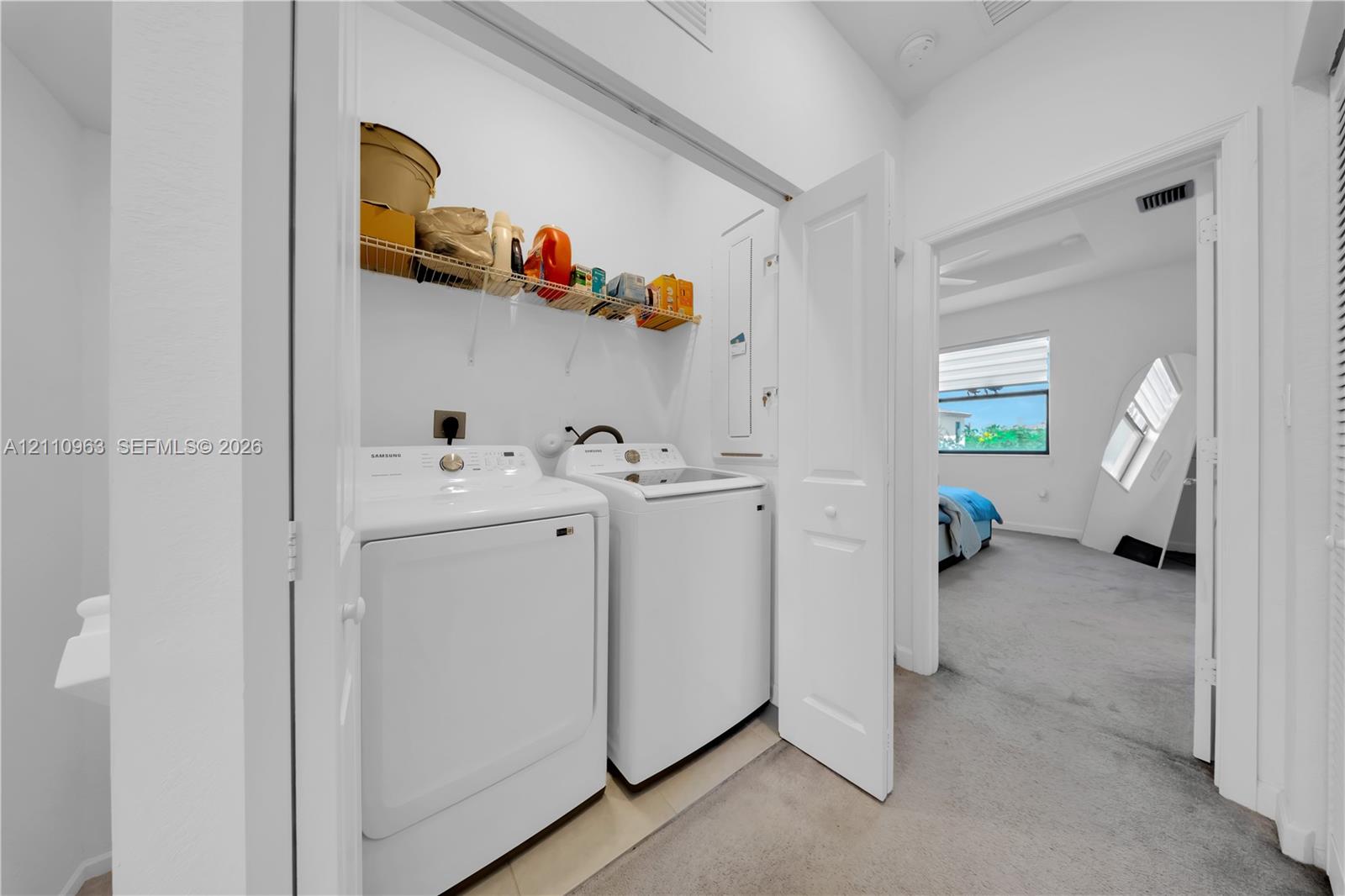 Laundry closet featuring wire shelving and neutral carpeting