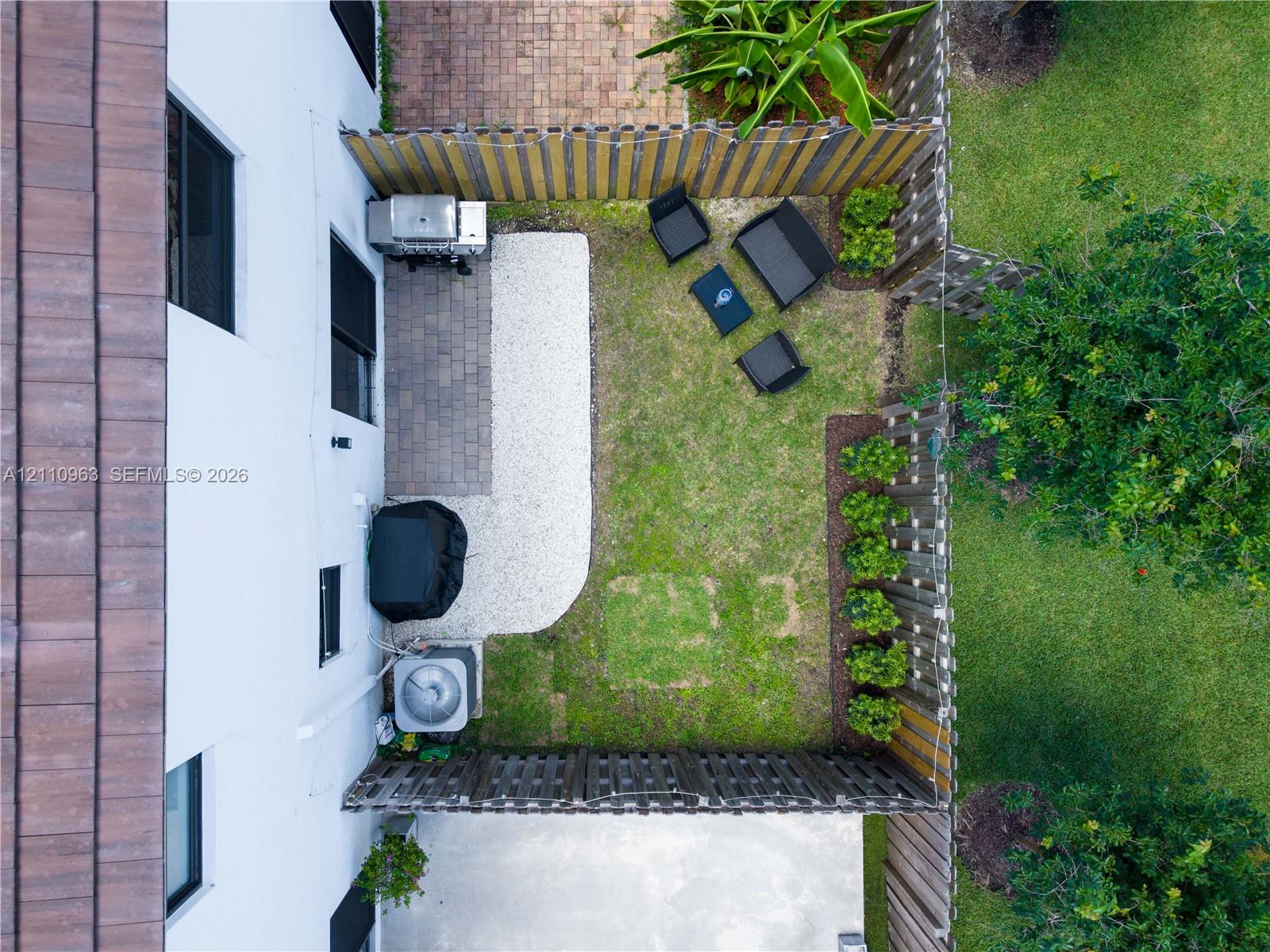 Fenced outdoor area featuring paver patio, gravel ground cover, and structured landscaping