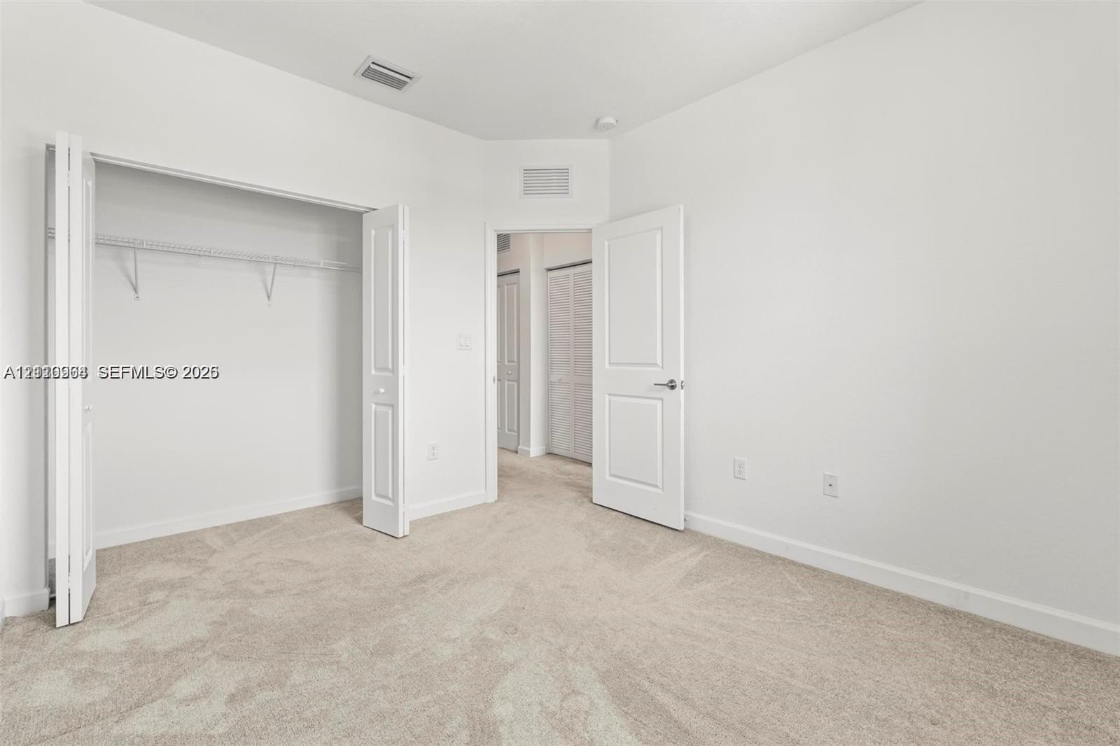 Neutral interior featuring neutral-toned carpeting, bi-fold closet doors, and multi-panel interior doors