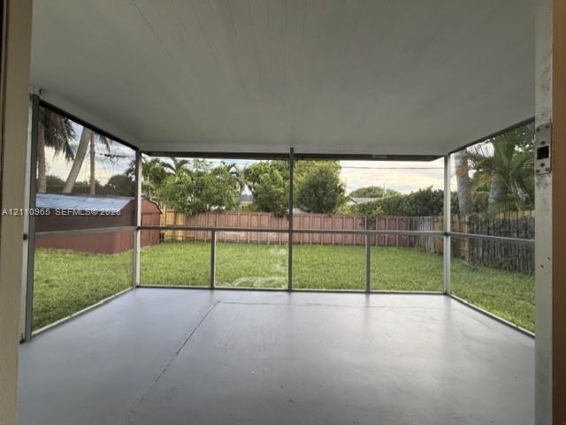 Screened-in porch featuring a painted concrete floor, solid ceiling, and metal framing