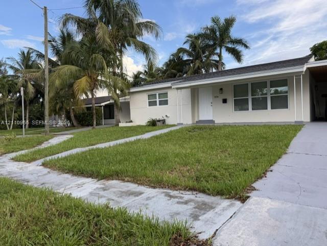 Single-story exterior featuring a light-toned facade, multi-pane windows, covered entryway, and mature palm trees Single-story exterior featuring a light-toned facade, multi-pane windows, covered entryway, and mature palm trees