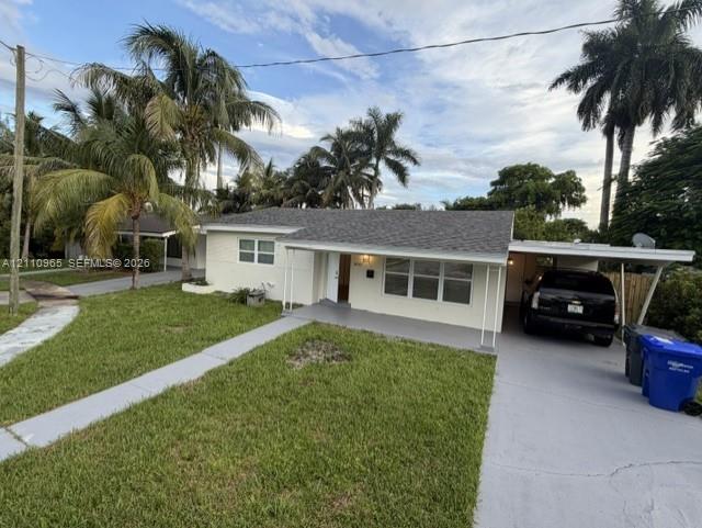 Single-story exterior featuring a shingled roof, attached carport, concrete walkway, and landscaped yard with mature palm trees Single-story exterior featuring a shingled roof, attached carport, concrete walkway, and landscaped yard with mature palm trees