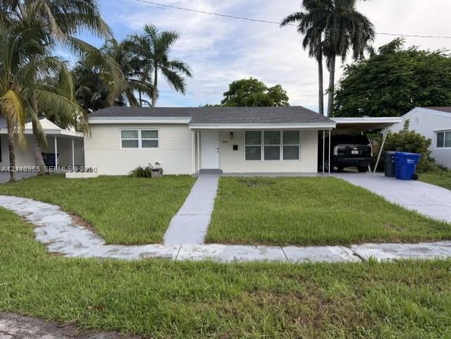 Single-story residence featuring a painted masonry exterior, composite shingle roof, attached carport, and concrete driveway Single-story residence featuring a painted masonry exterior, composite shingle roof, attached carport, and concrete driveway