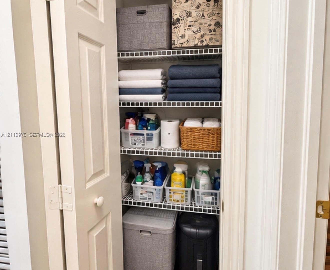 Storage closet featuring multi-tiered wire shelving and double-panel doors