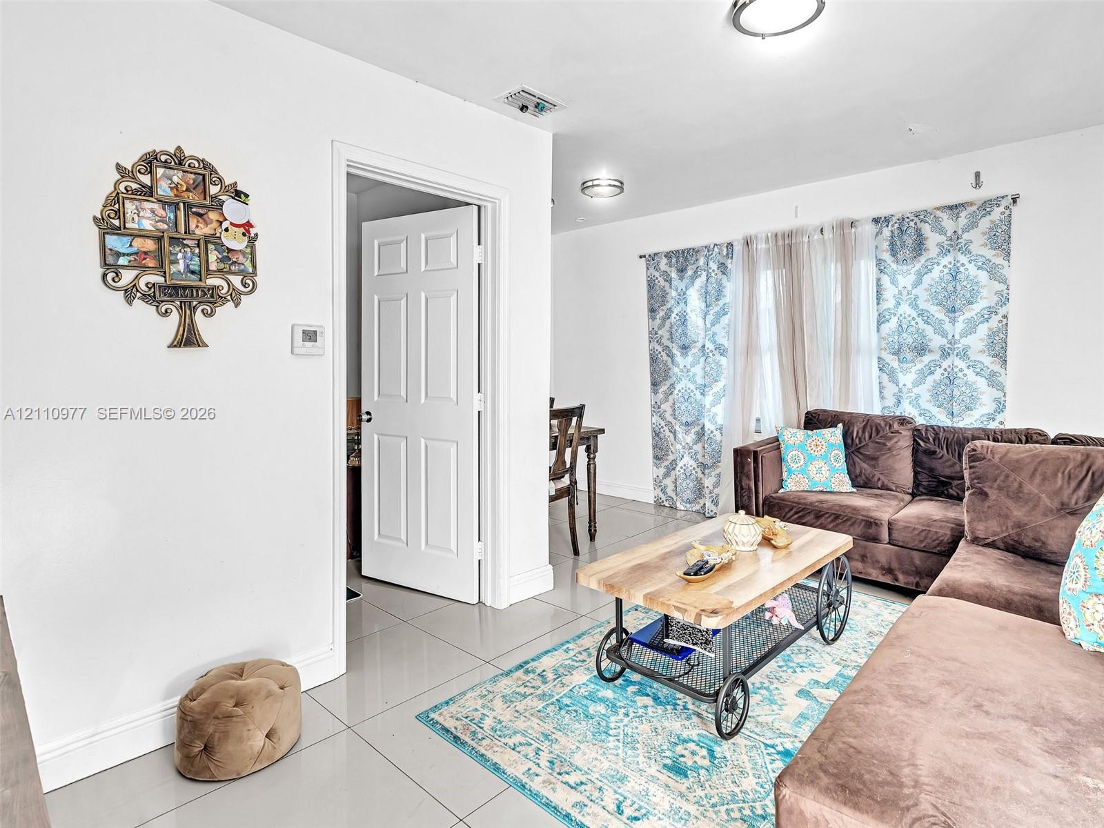 Large-format tile flooring, flush-mount ceiling lighting, and a multi-panel interior door Large-format tile flooring, flush-mount ceiling lighting, and a multi-panel interior door