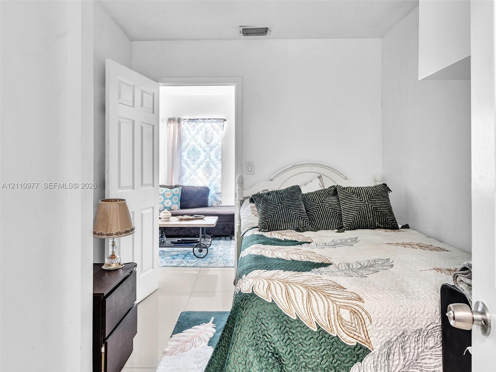 Neutral wall color, high-gloss tile flooring, and a classic six-panel interior door