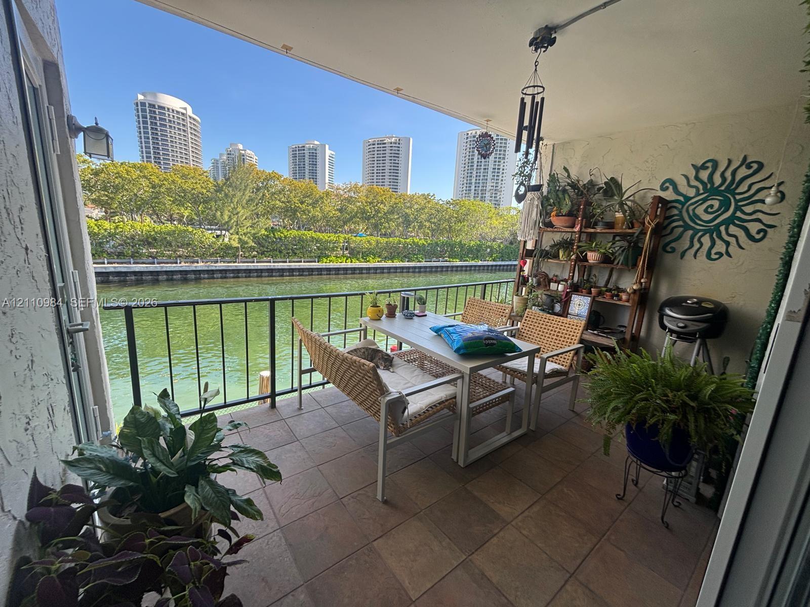 Covered balcony featuring tile flooring and a metal railing overlooking the waterway Covered balcony featuring tile flooring and a metal railing overlooking the waterway