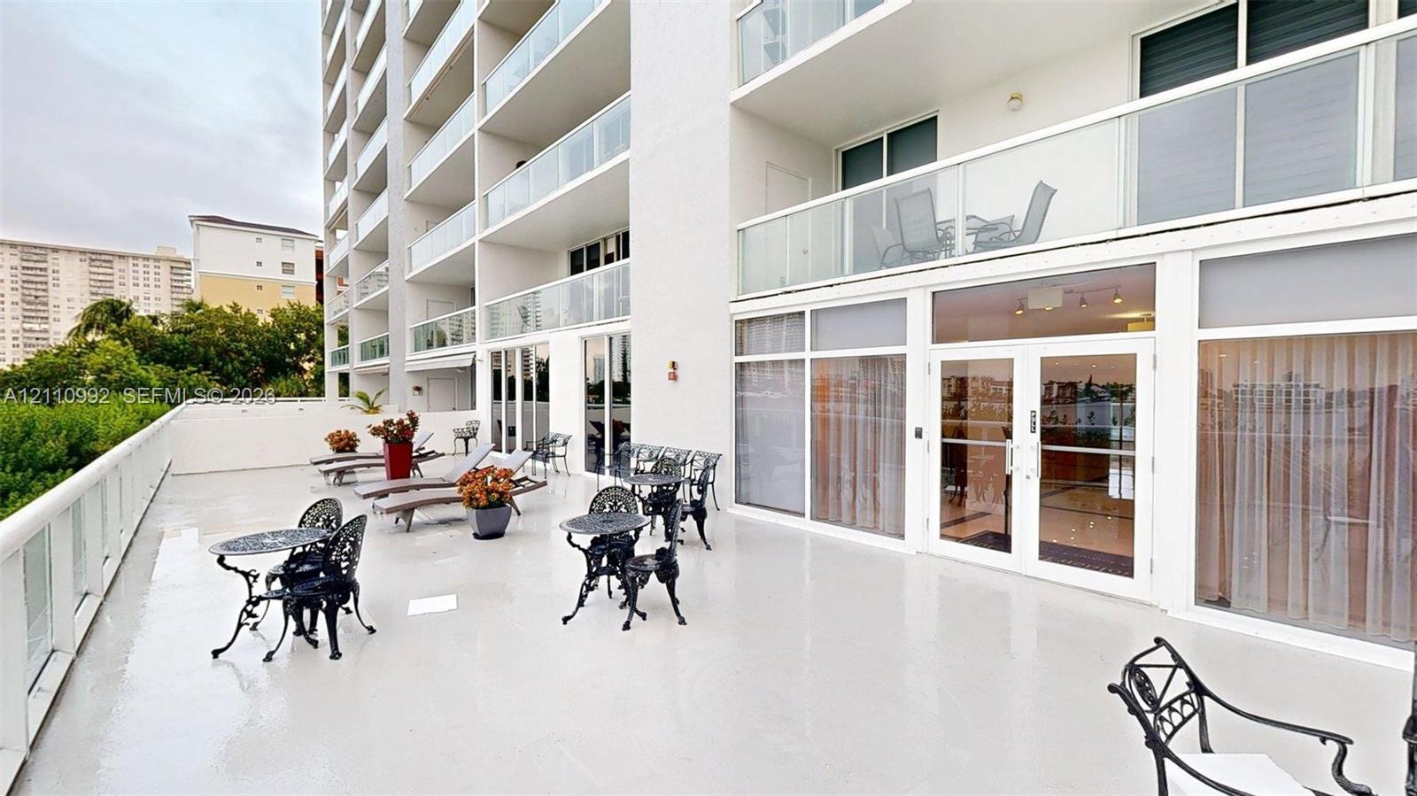 Expansive outdoor terrace featuring smooth surface flooring, floor-to-ceiling glass panel doors, and glass-paneled railings