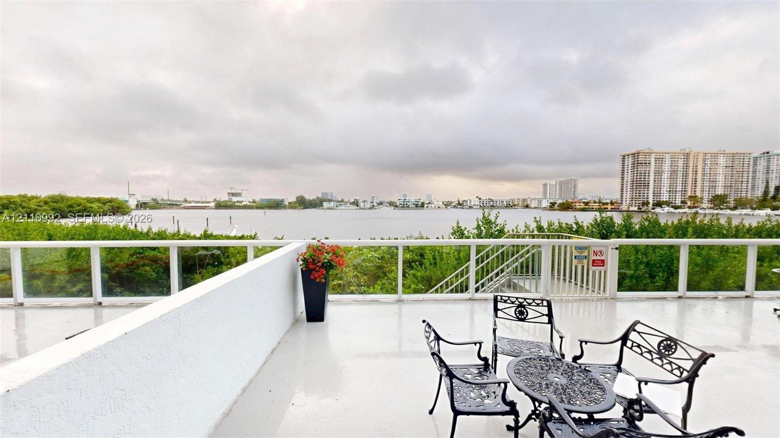 Expansive open-air deck featuring a smooth surface finish, structural white railing, and a gate