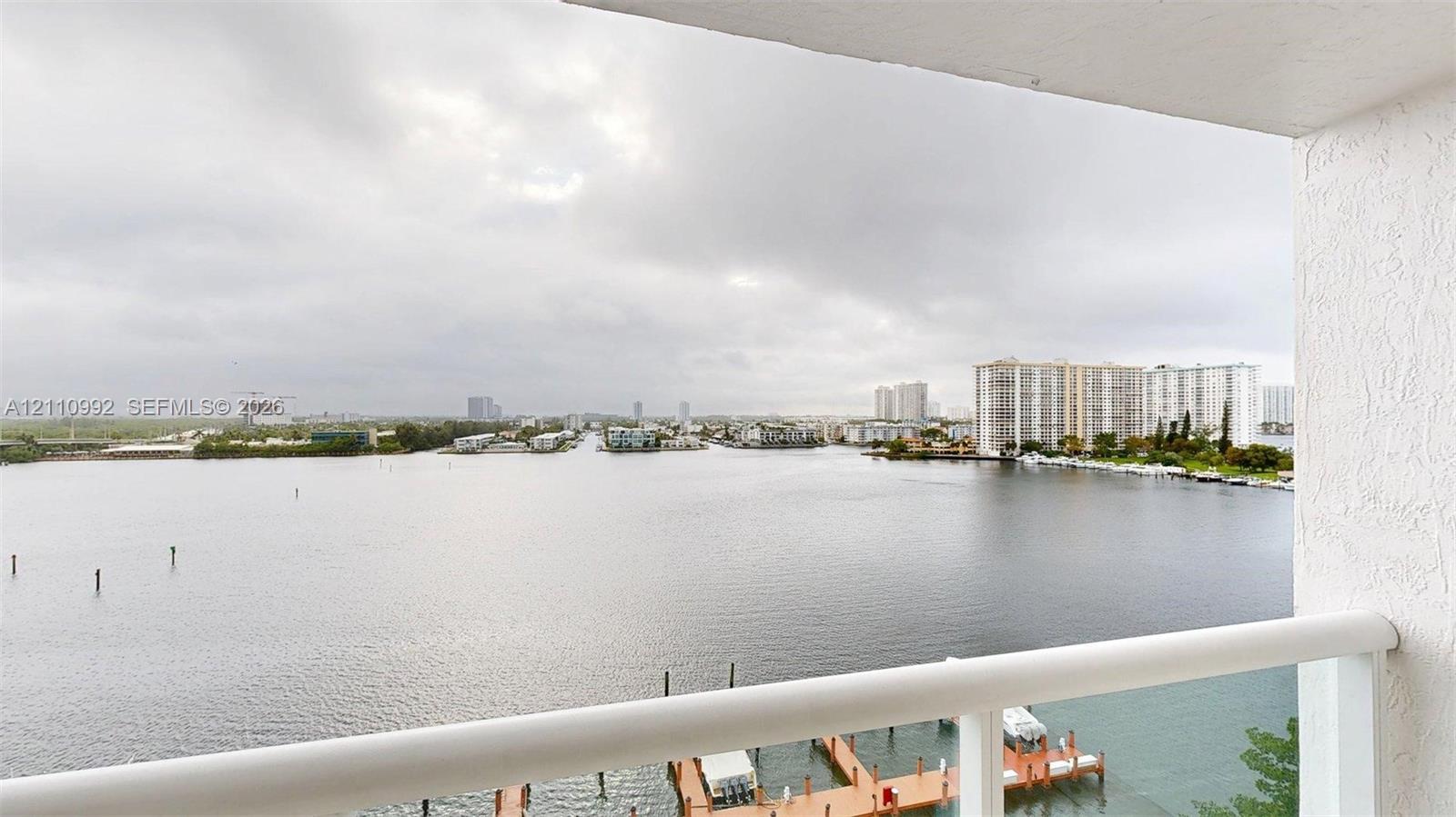 Covered balcony featuring white structural railings and direct water frontage